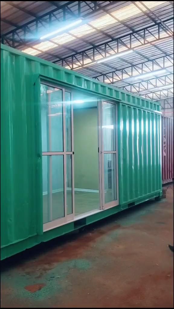 a green shipping container with doors and windows