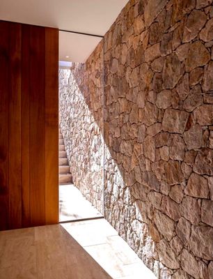 a stone wall next to a wooden door