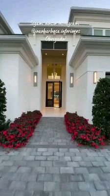 a white house with red flowers in front of it