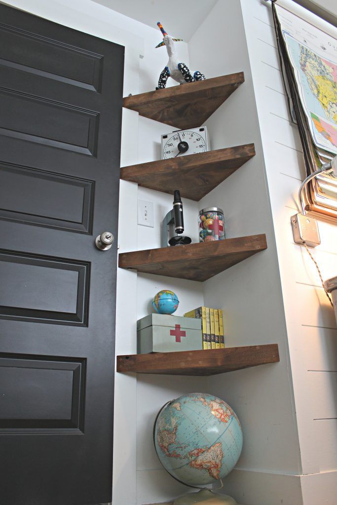 a black door and some shelves in a room