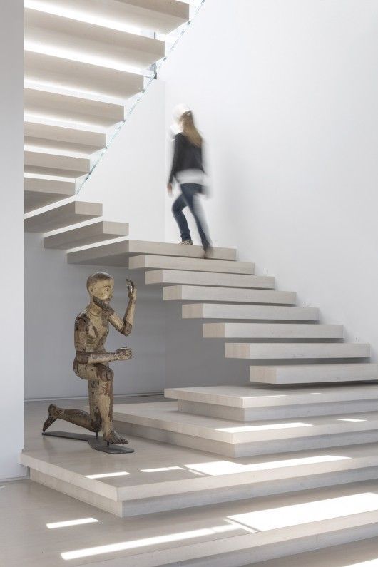 a woman standing on a stair case next to a statue