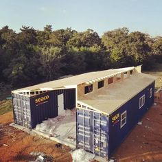 a large blue shipping container sitting on top of a dirt field