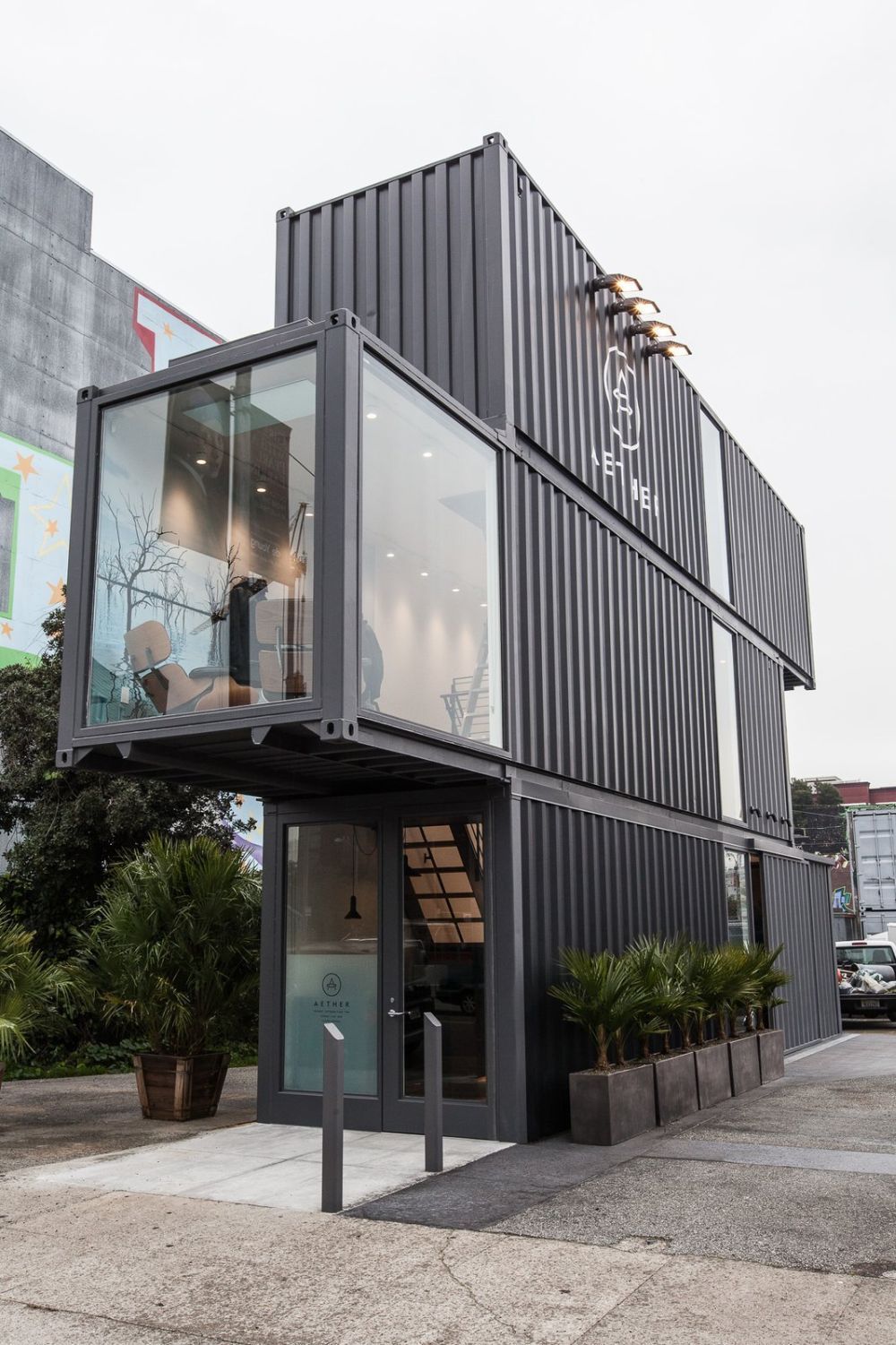 a building made out of shipping containers on the side of a street