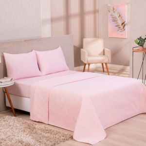 a bed with pink sheets and pillows in a room