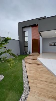 a modern house with a wooden walkway leading to the front door