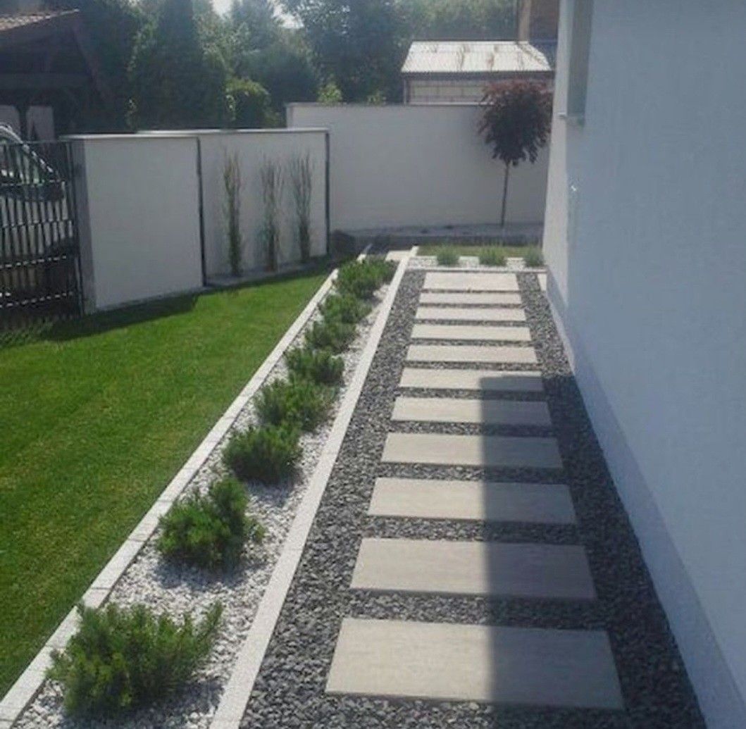 a garden with a white fence and grass