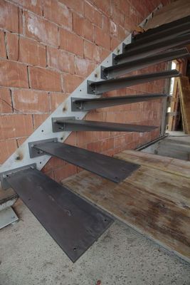 a set of metal stairs next to a brick wall