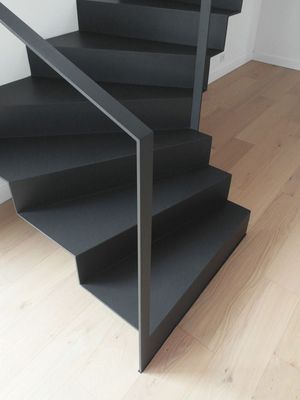 a set of black stairs on a wooden floor