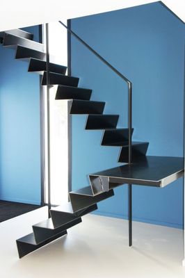 a set of black metal stairs in a blue room