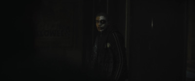 a creepy looking person standing in a dark room