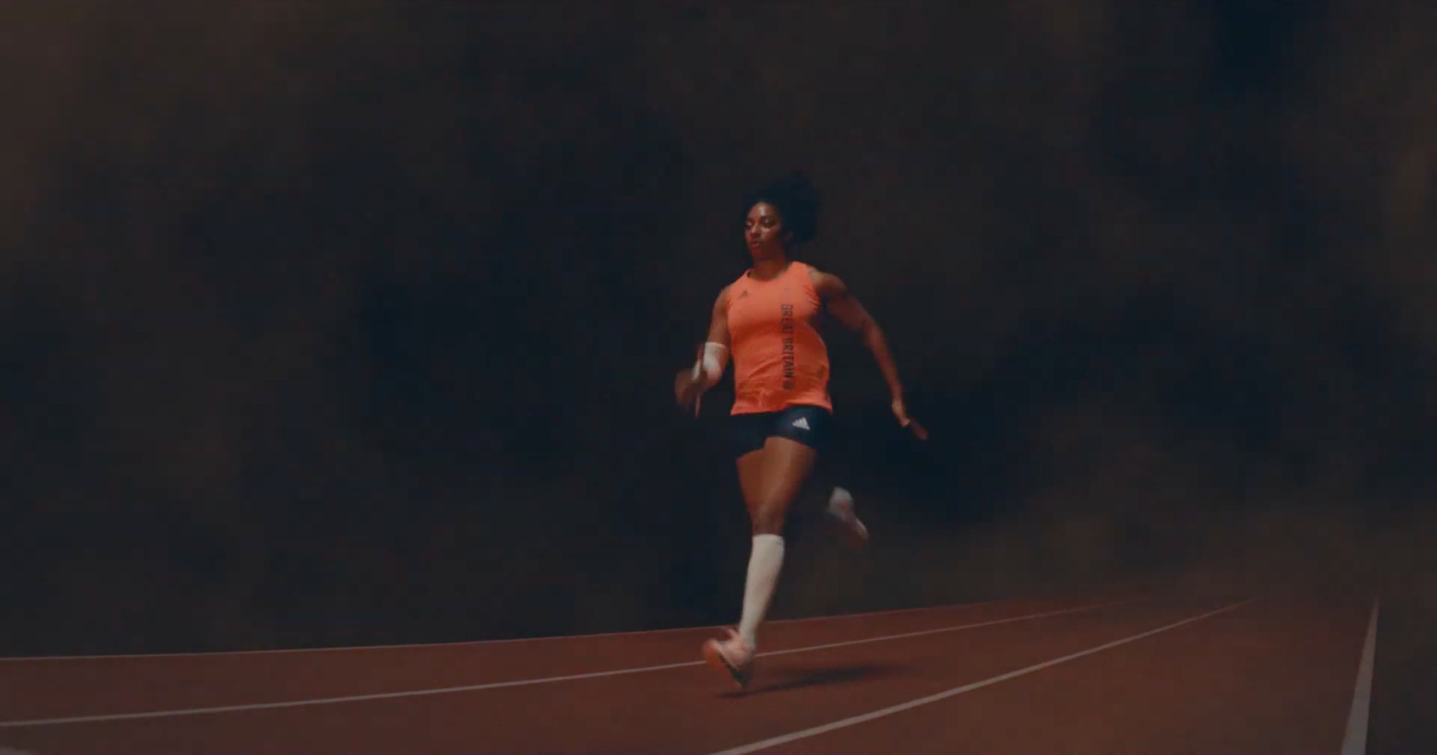 a woman is running on a track in the dark