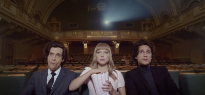 two men and a woman sitting in a theater