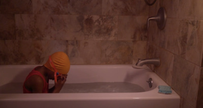 a person in a bathtub with a towel on their head