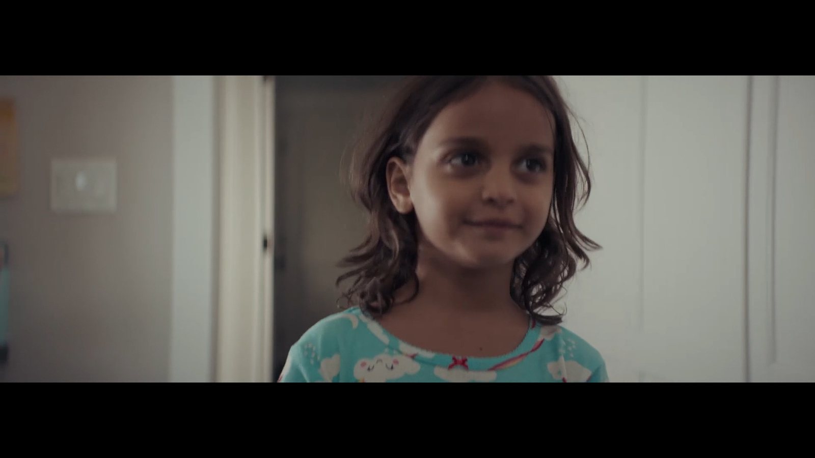 a little girl standing in front of a door