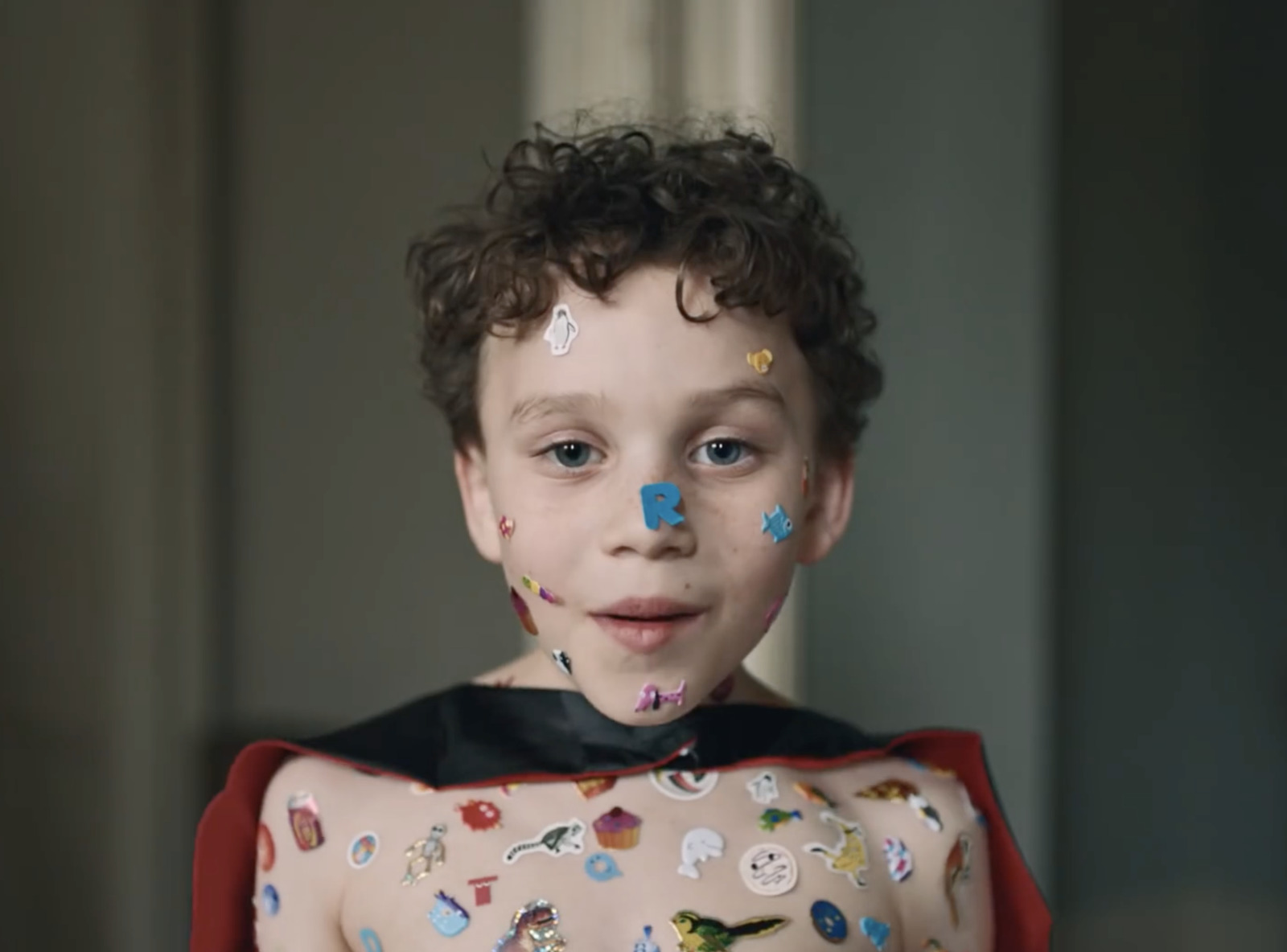 a young boy wearing a costume with stickers on his face