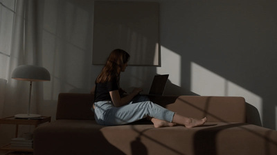 a woman sitting on a couch with a laptop