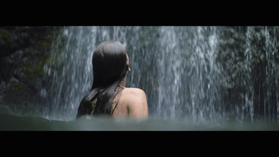 a woman standing in front of a waterfall