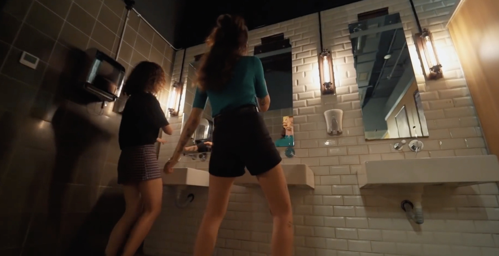 a woman standing in a bathroom next to a sink