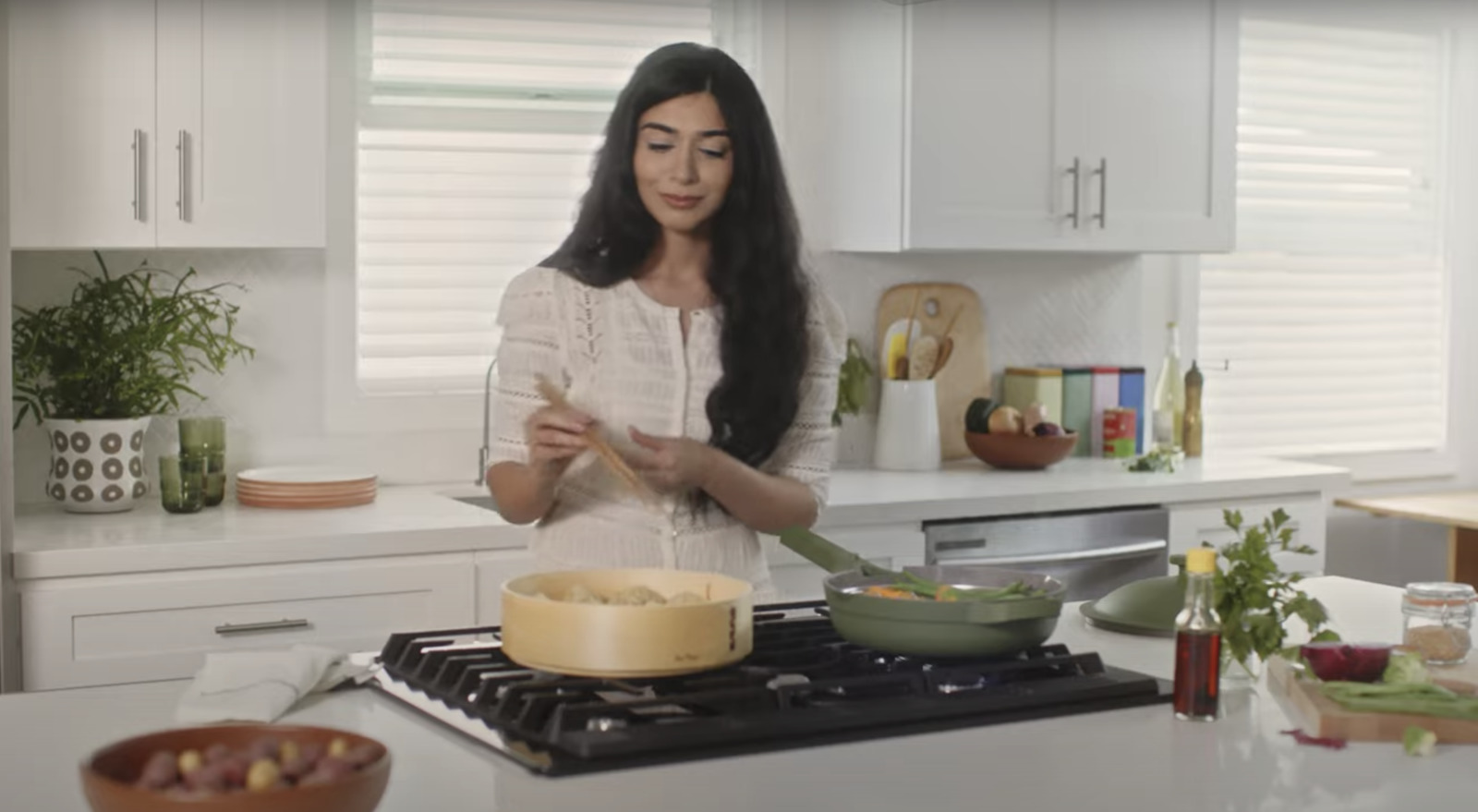 a woman standing in a kitchen preparing food