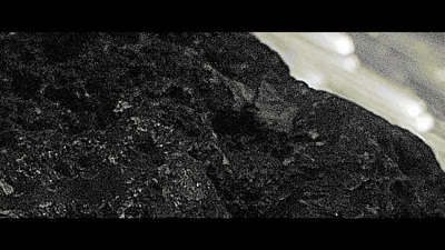 a black and white photo of rocks and water