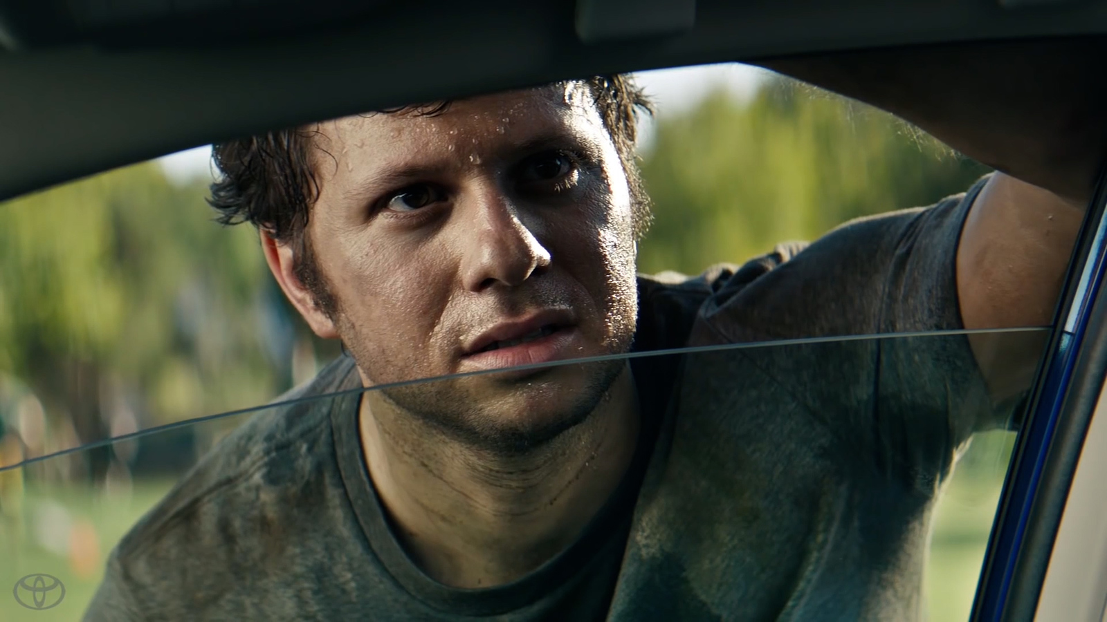 a man sitting in a car looking out the window