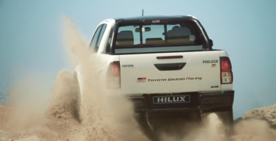 a white pick up truck driving through sand