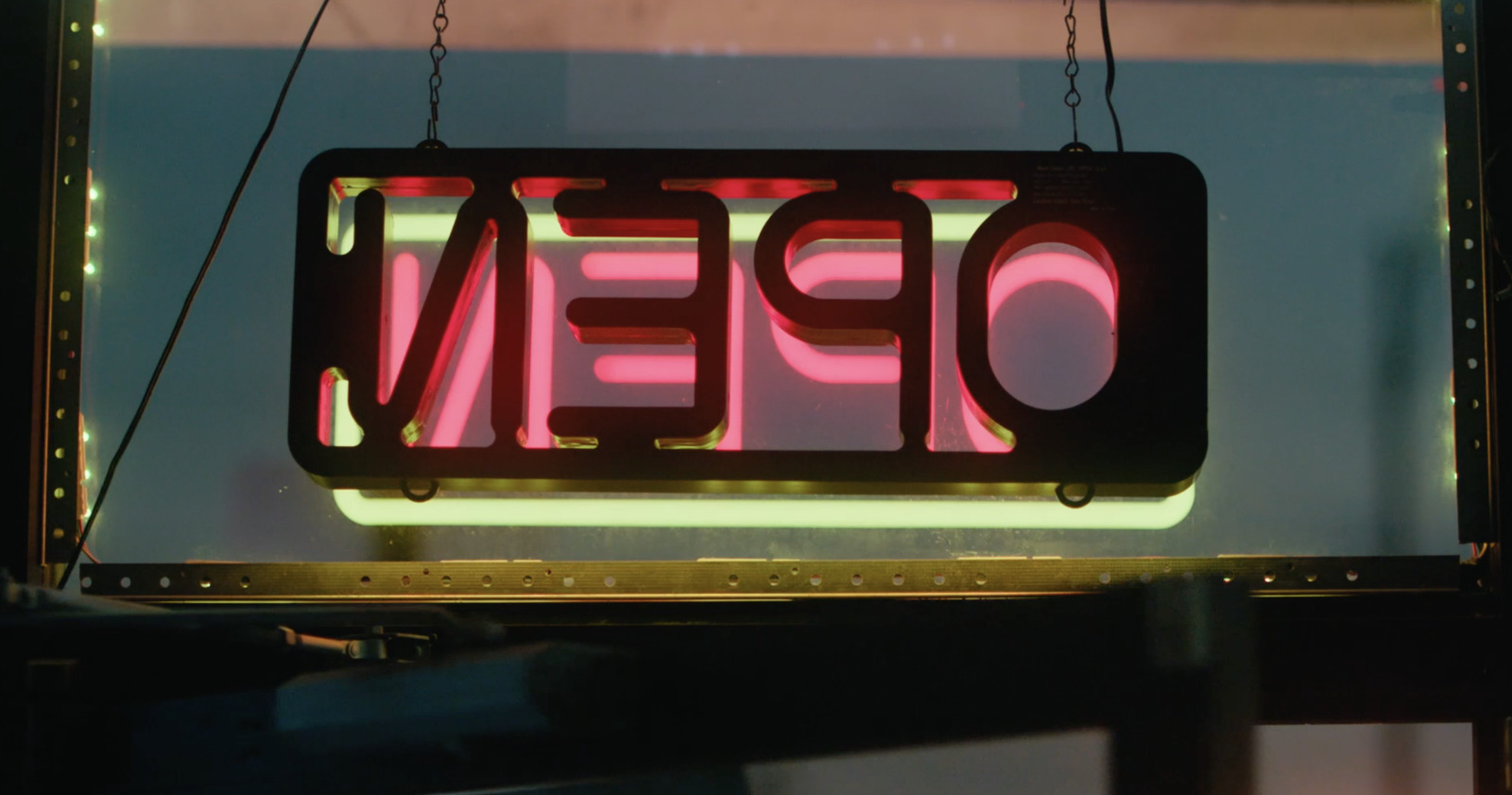 a neon open sign hanging from the side of a building