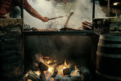 a person cooking food on a grill over a fire