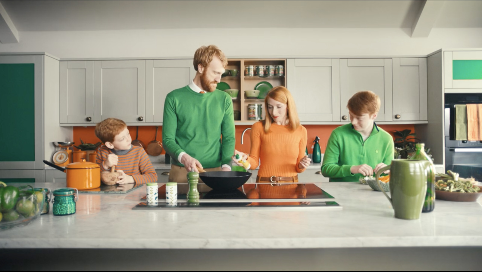 a group of people standing in a kitchen preparing food