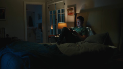 a man sitting on a bed reading a book