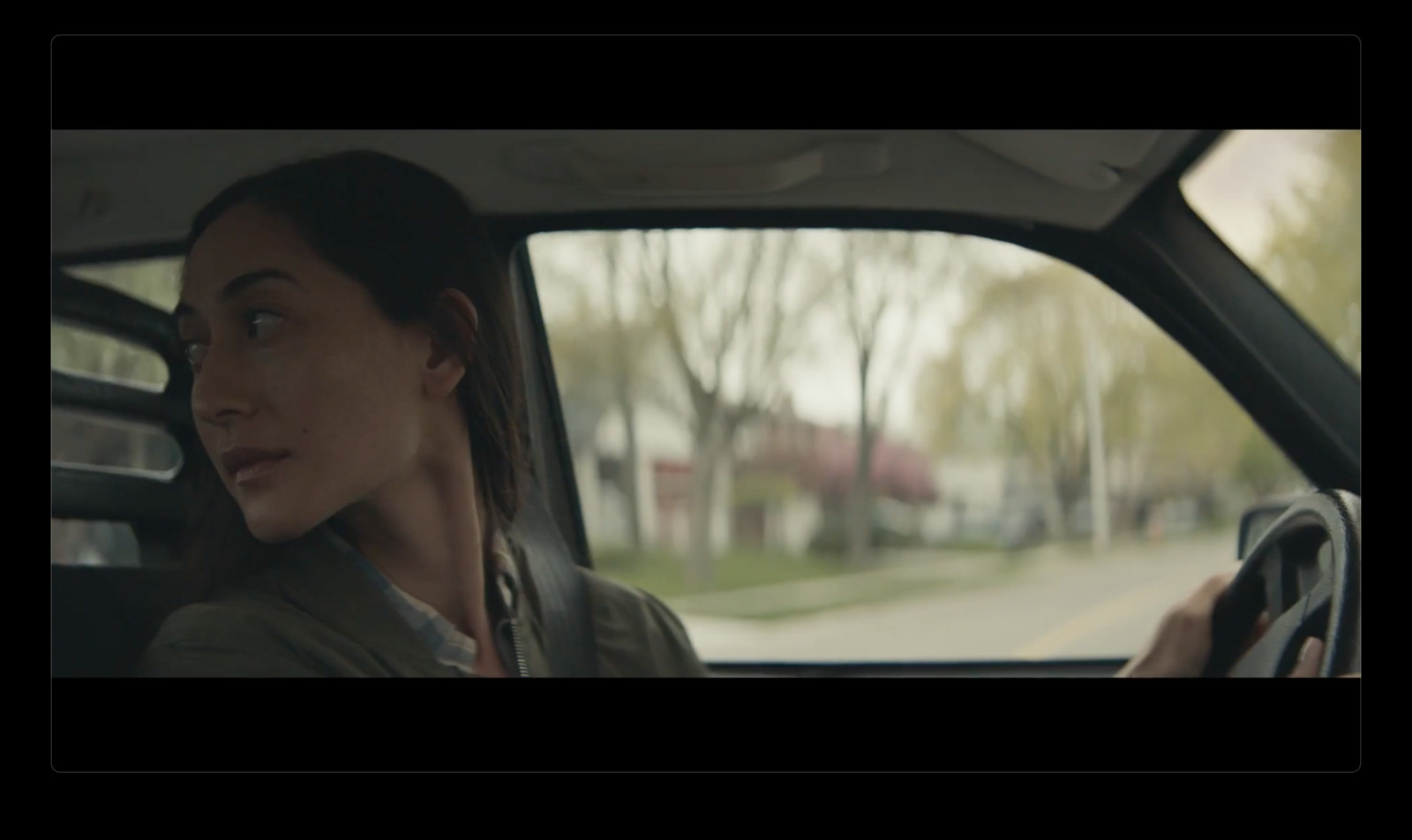 a woman driving a car on a city street