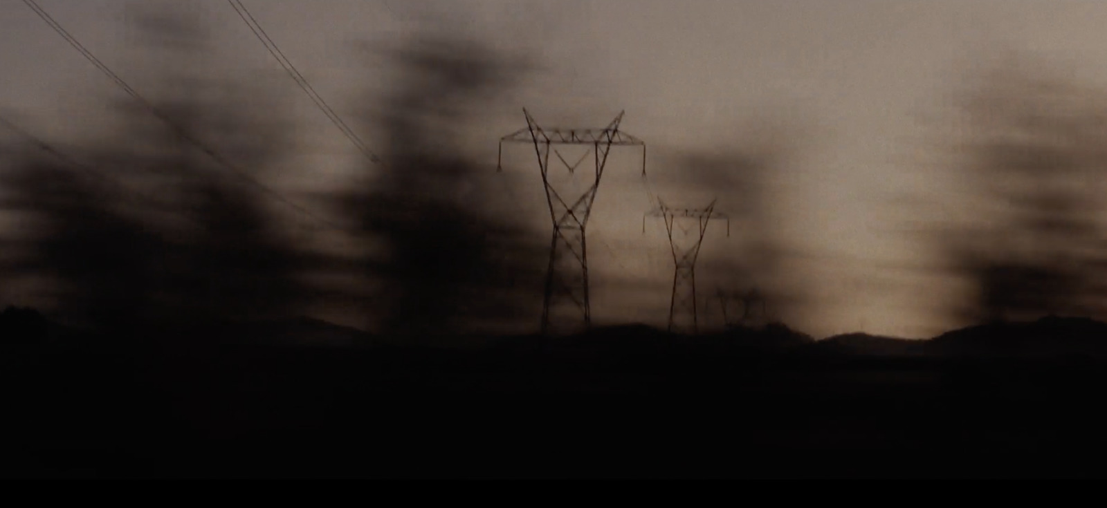 a dark picture of power lines in the distance