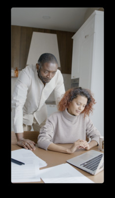 a man and a woman sitting at a table with laptops