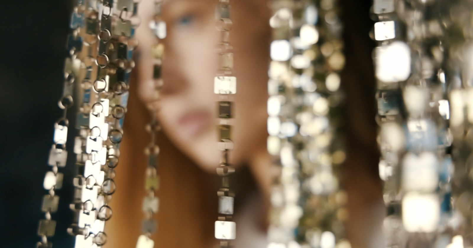 a close up of a woman's face through beads