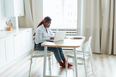 a woman sitting at a table using a laptop computer