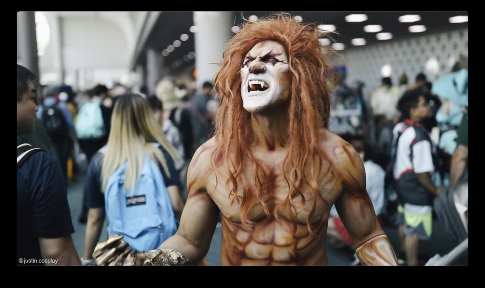 a man with long red hair and white makeup