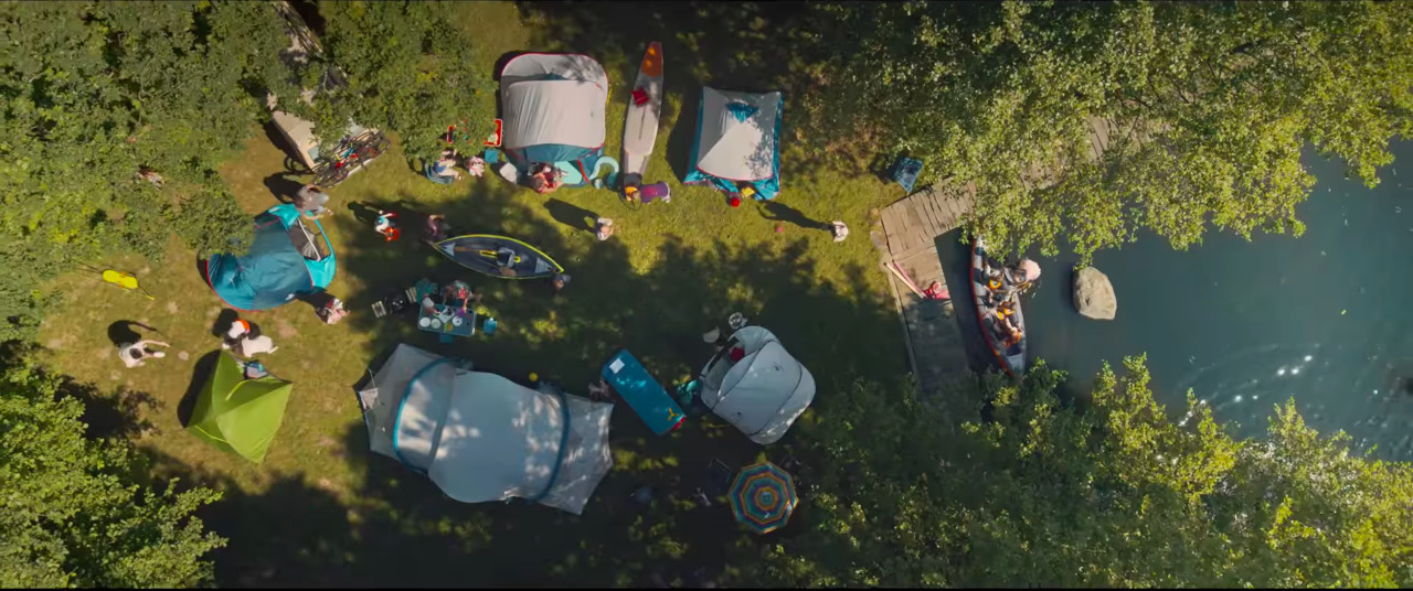 an aerial view of a group of people sitting around tents