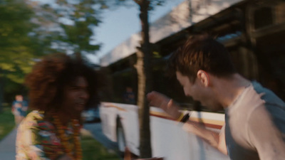 a man and a woman standing in front of a bus