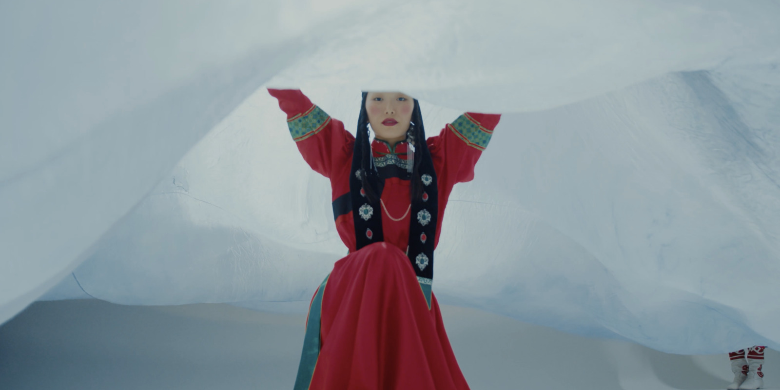 a woman in a red dress standing in the snow