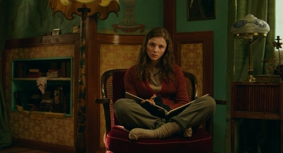 a woman sitting in a chair reading a book