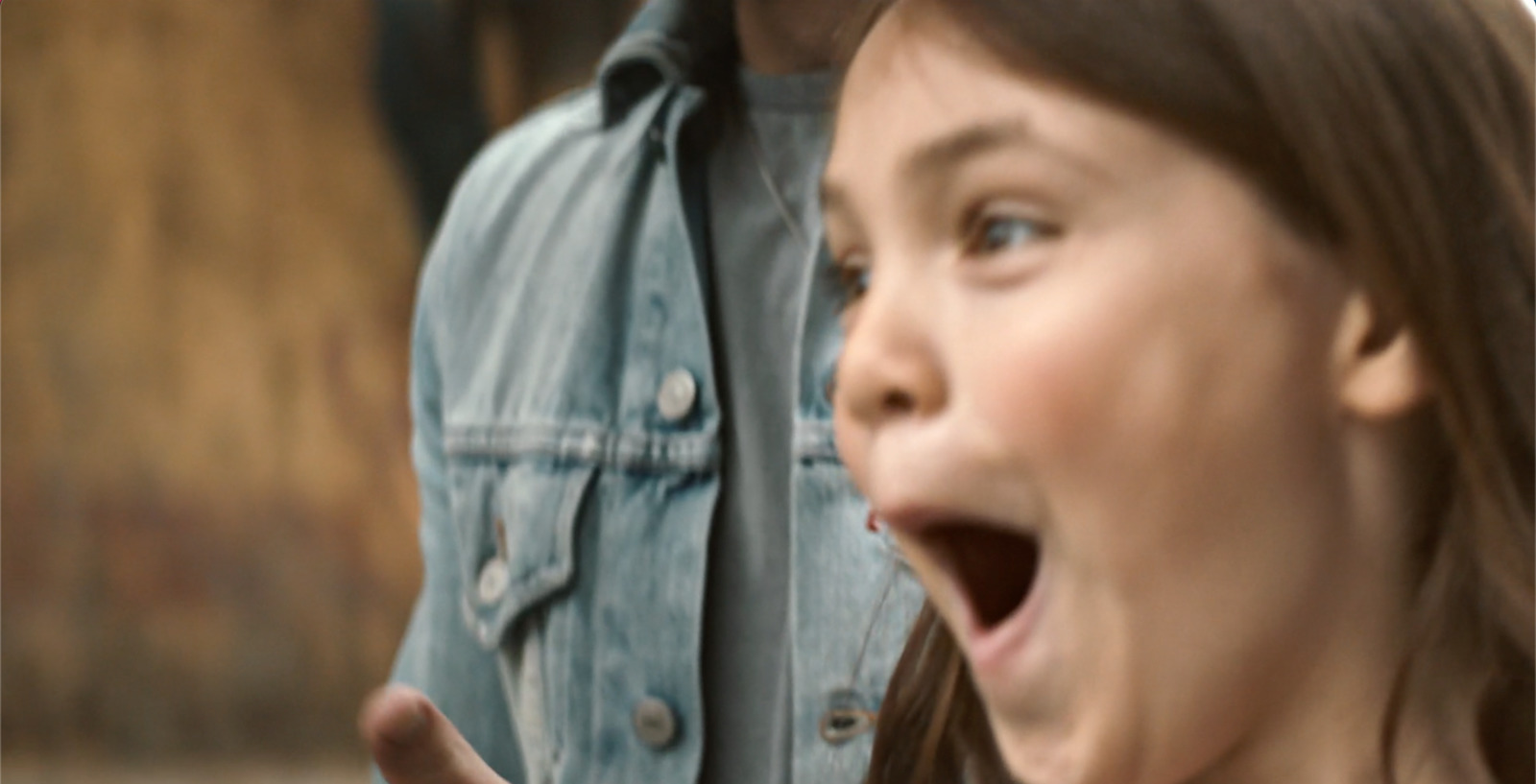 a young girl making a funny face while standing next to a man