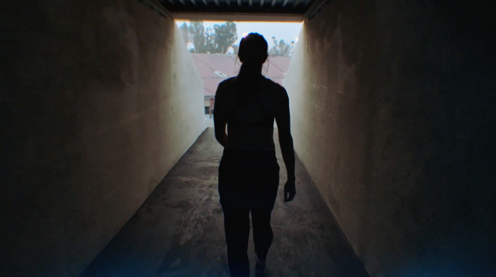 a man is walking down a dark hallway