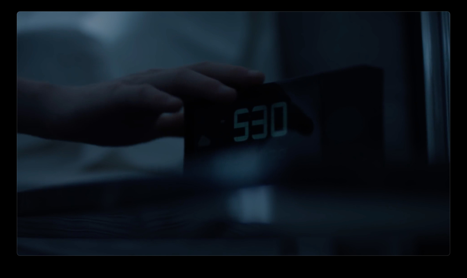 a person holding a digital clock in their hand