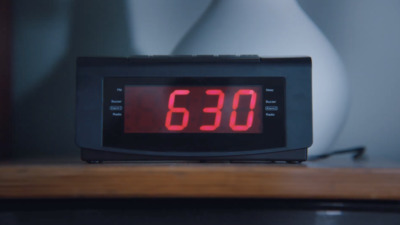 a digital clock sitting on top of a wooden table