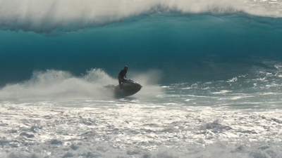 a man riding a wave on top of a surfboard