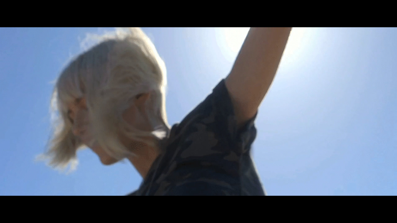 a man with white hair and a black shirt is flying a kite