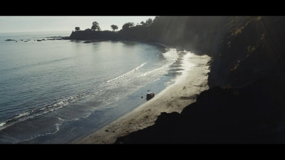 an aerial view of a beach with a boat in the water