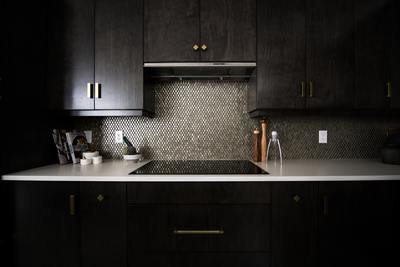 a kitchen with black cabinets and white counter tops