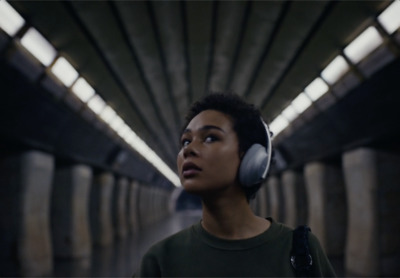 a woman wearing headphones standing in a tunnel