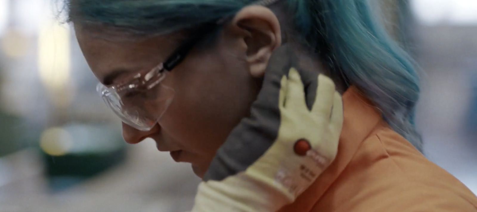 a woman with blue hair and glasses looking at her cell phone